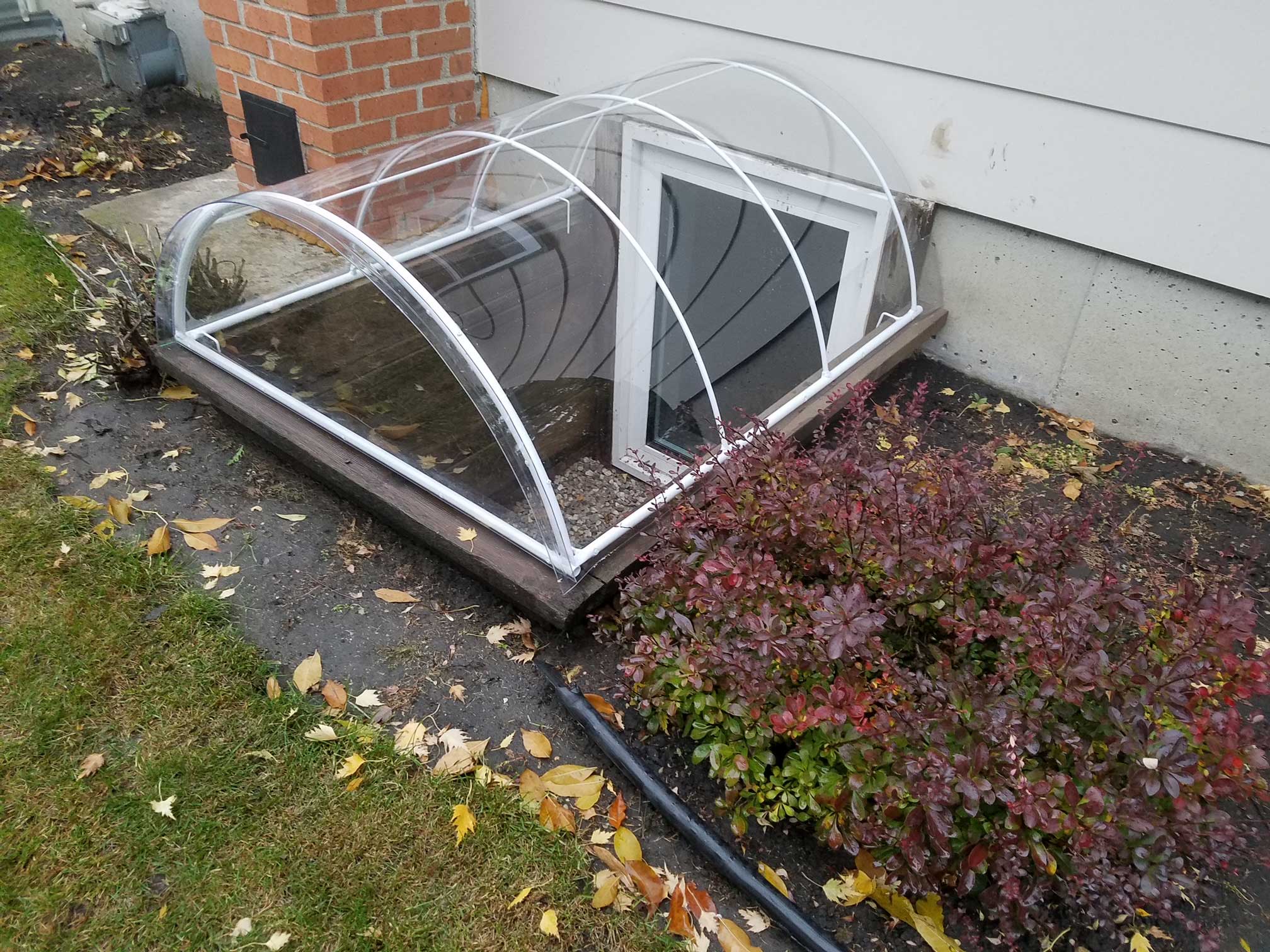 Window well cover with autumn leaves