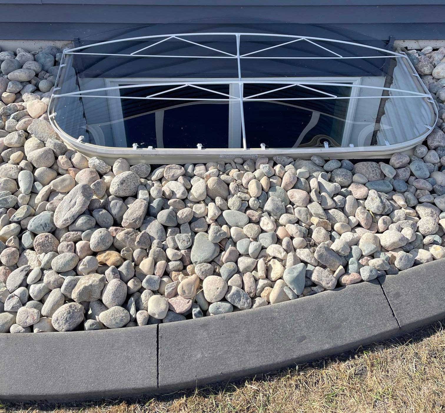 Stone-covered basement window well design