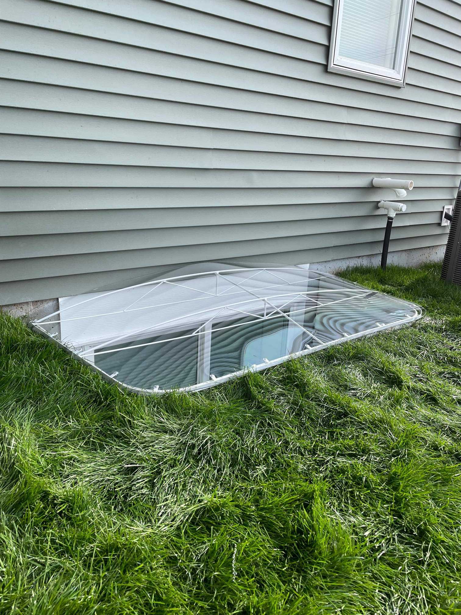 Basement window well with clear plastic cover
