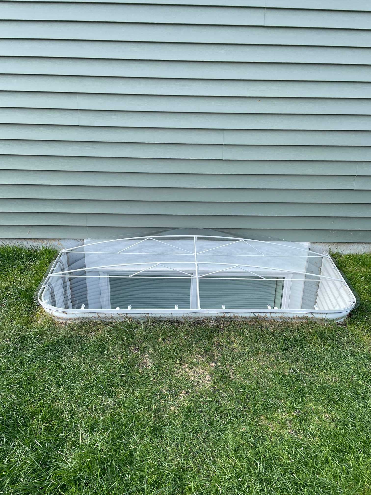 Basement window well with clear plastic cover