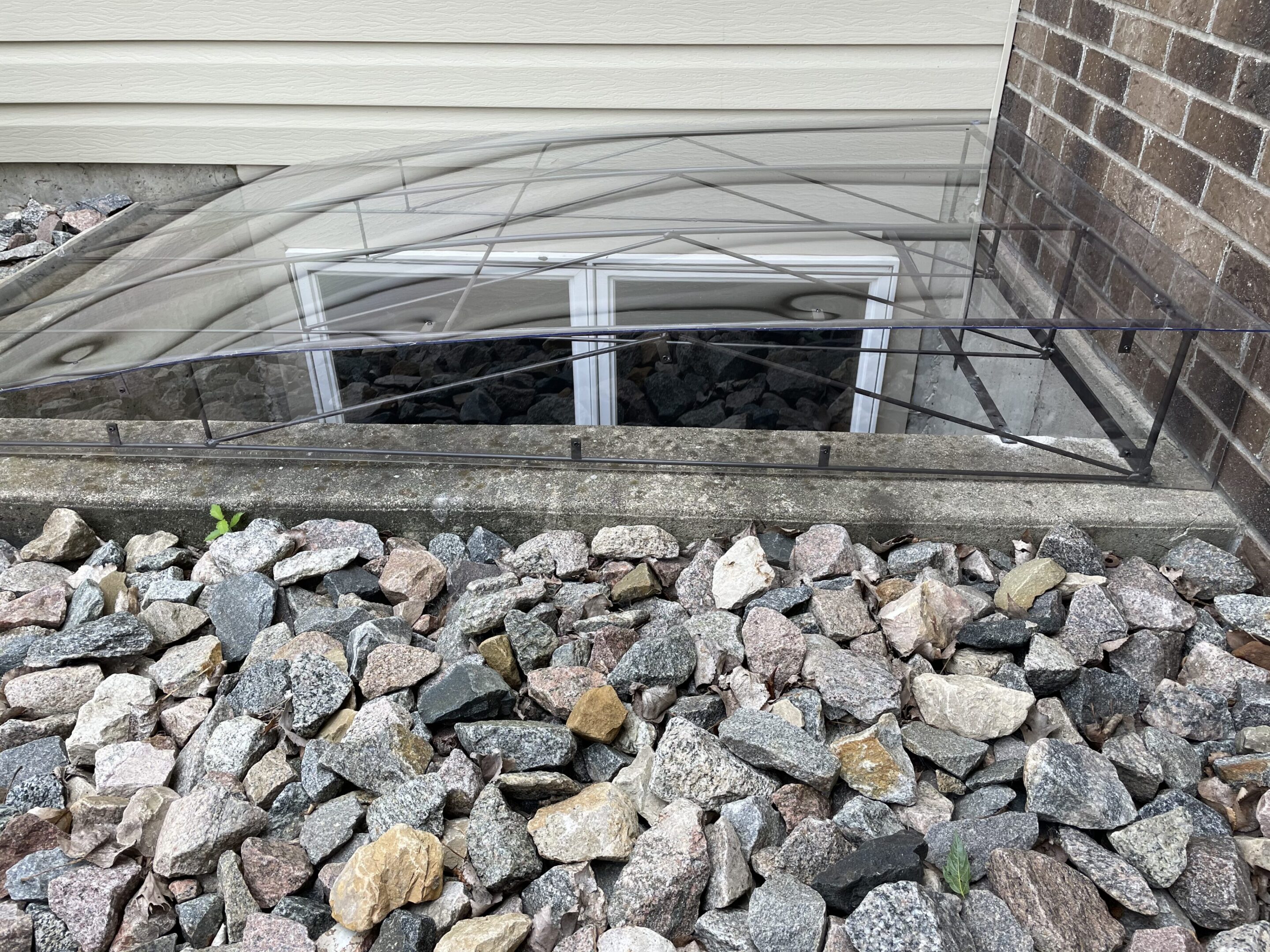 Arched window well cover over basement windows