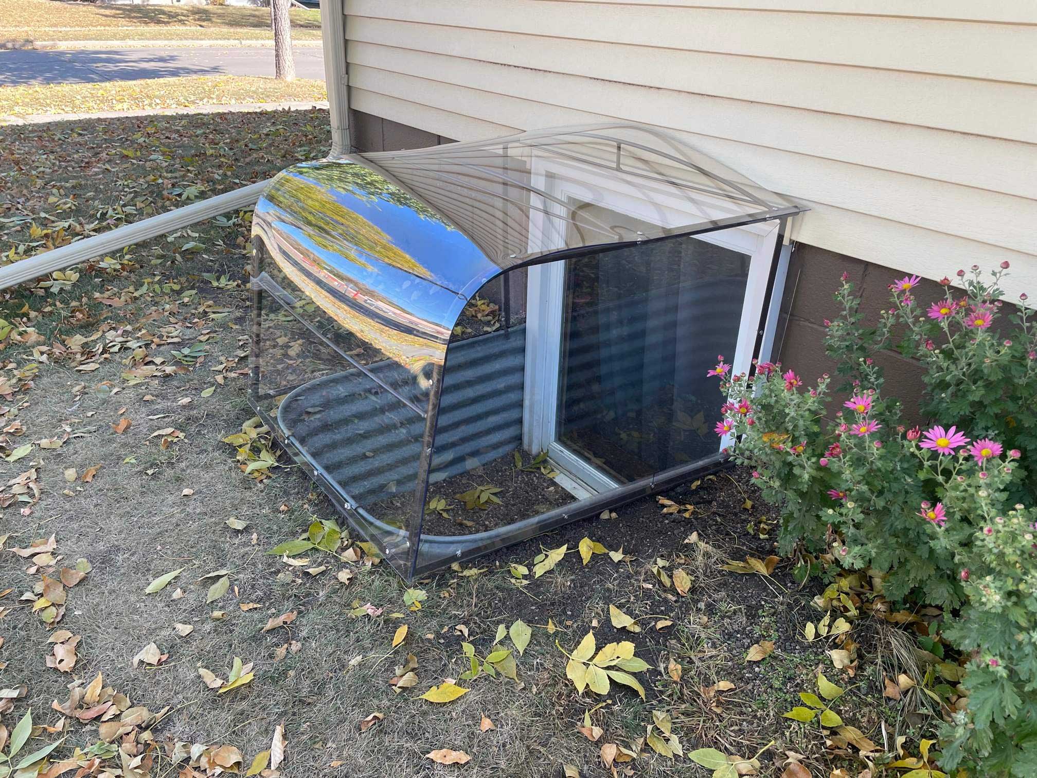 Clear plastic window well cover over basement window