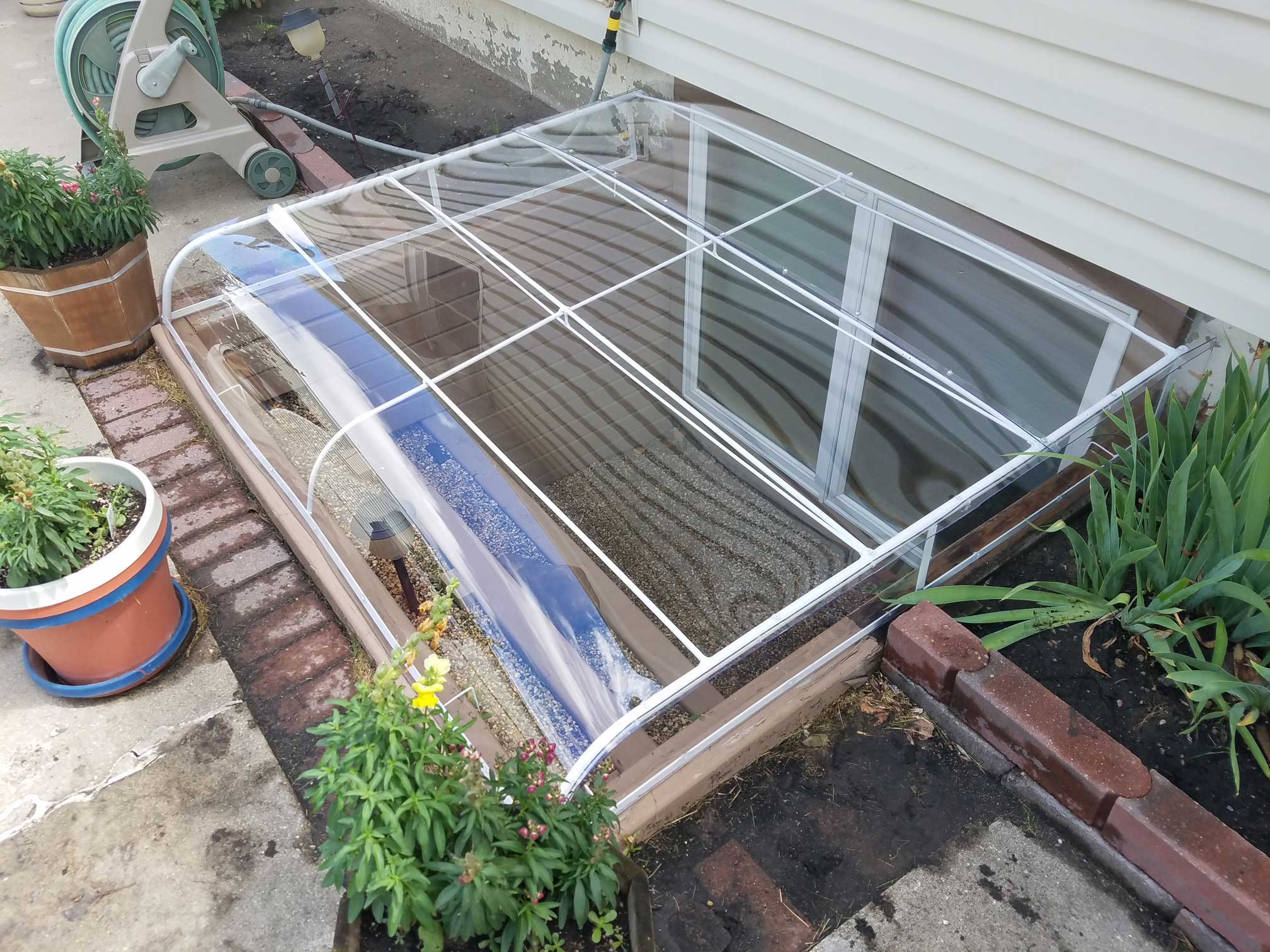 Clear plastic window well cover over basement window