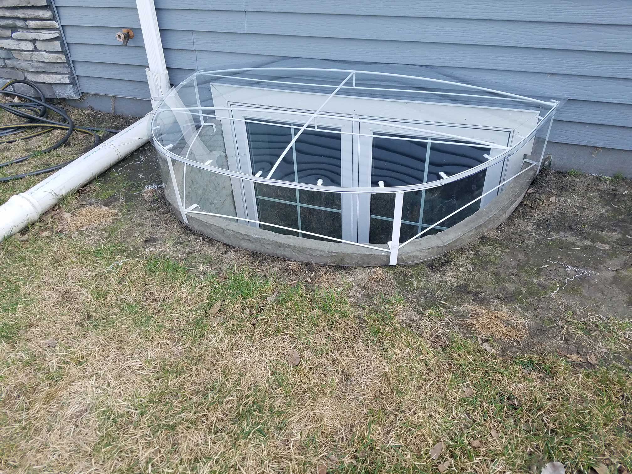 Basement window well with clear protective cover