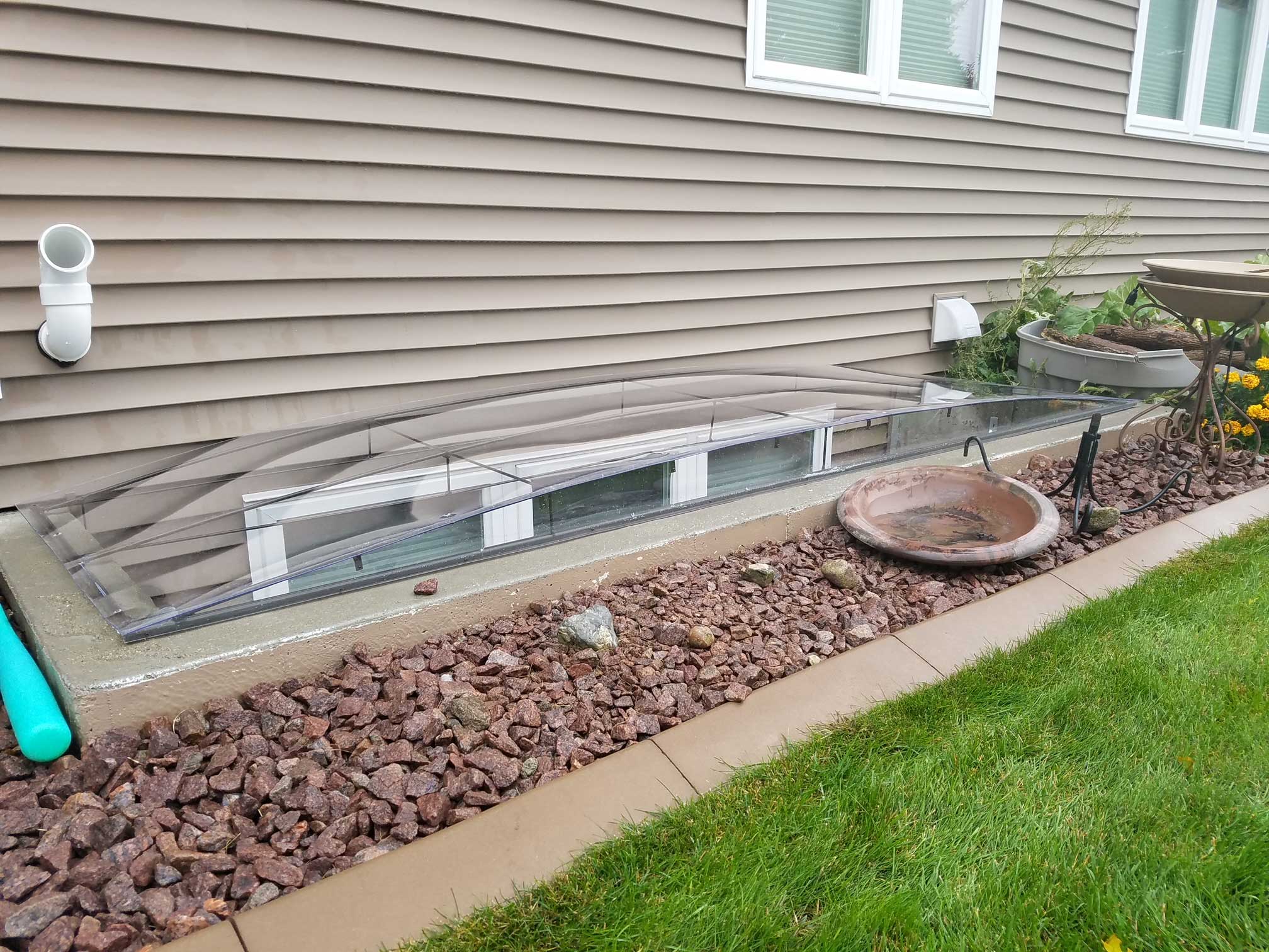 Basement window well with clear protective cover