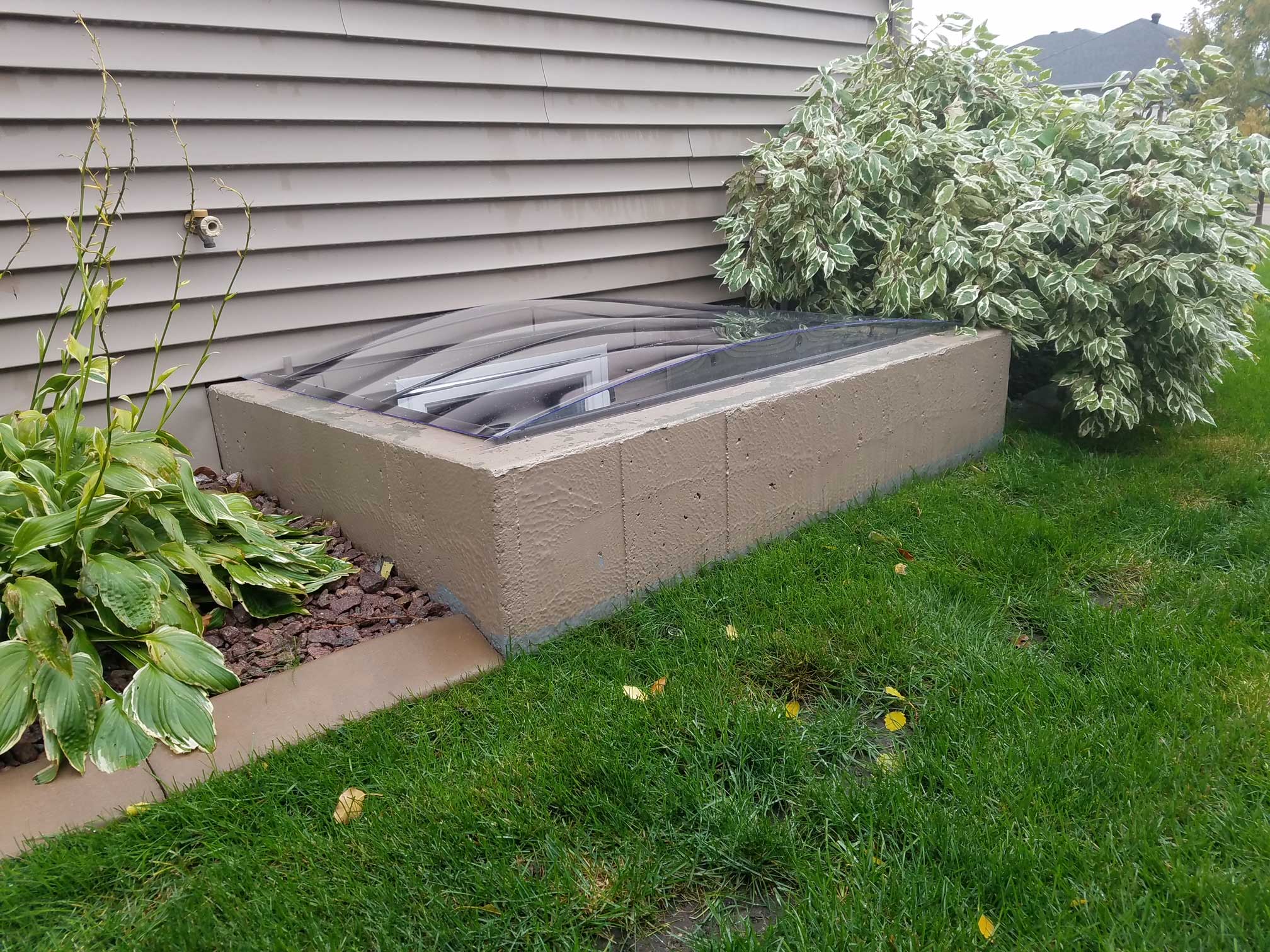 Basement window well with clear plastic cover