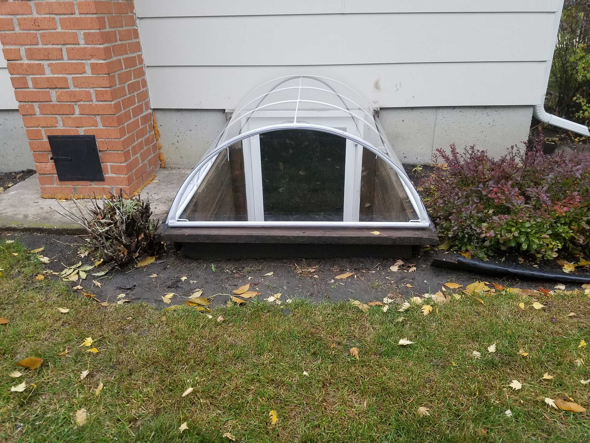 Arched clear basement window well cover