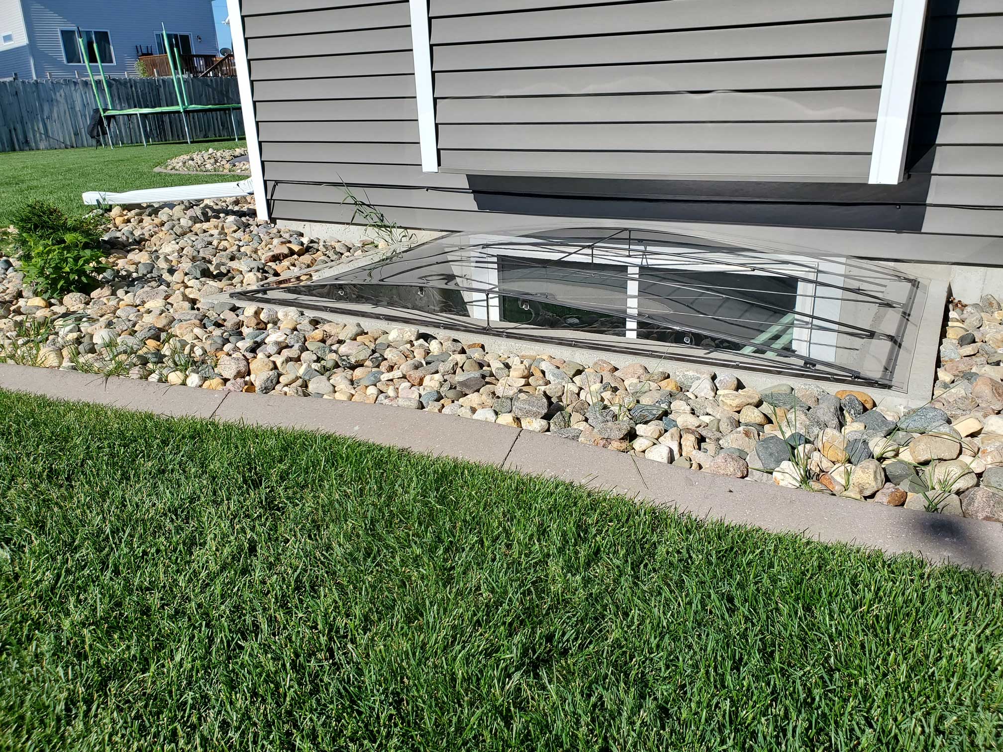 Basement window well with metal grate cover