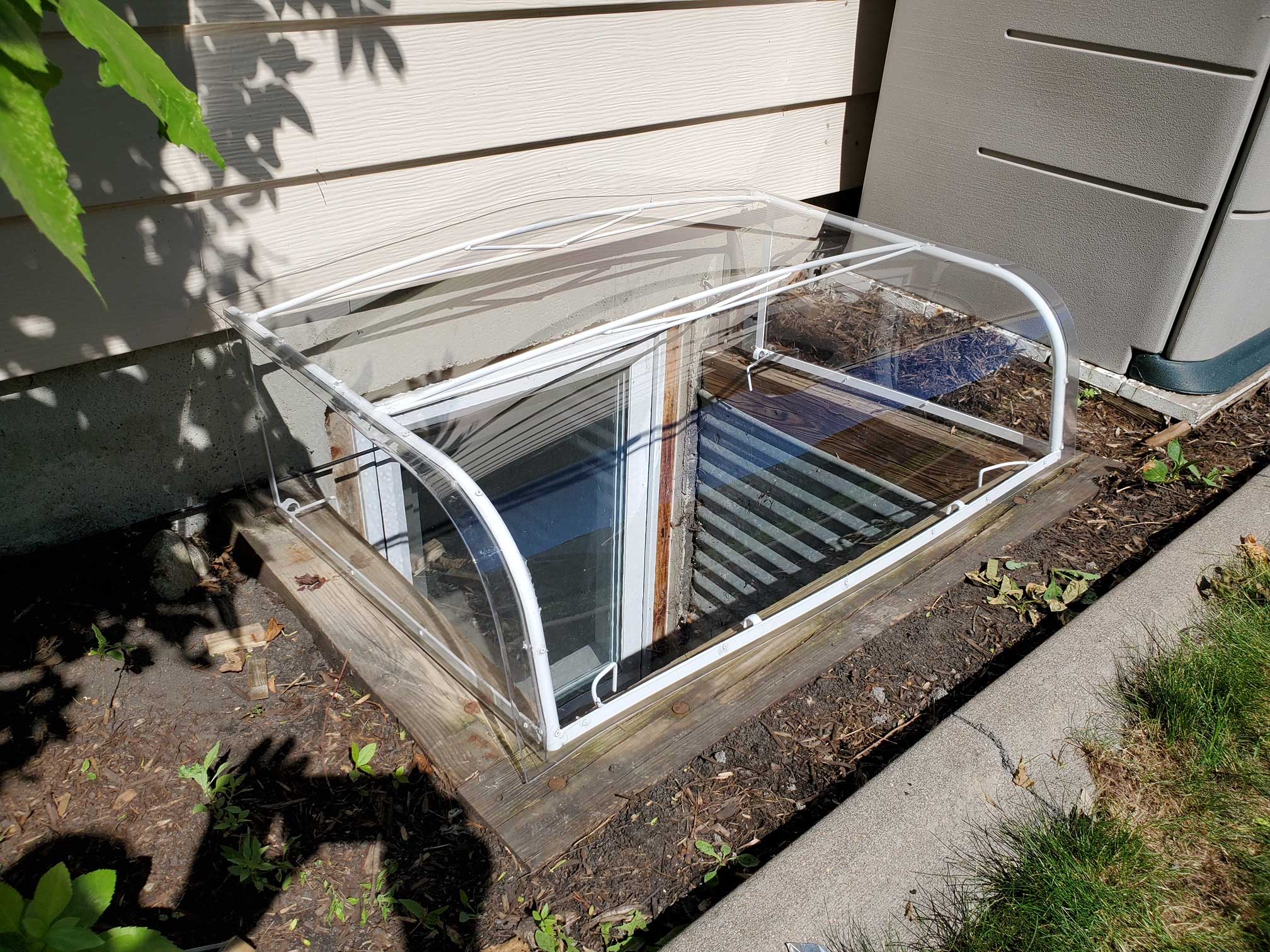 Clear acrylic window well cover over basement
