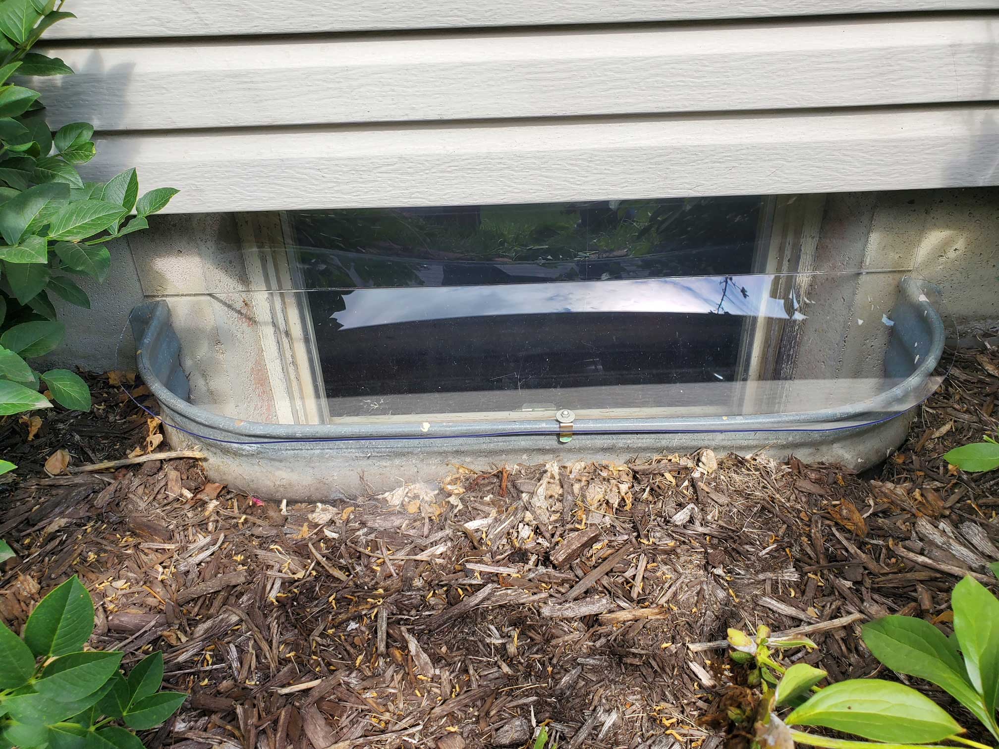 Basement window well with clear protective cover