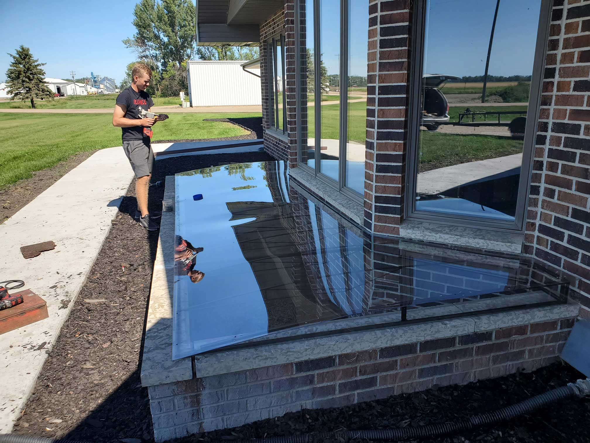 Man applying shiny epoxy over brick planter