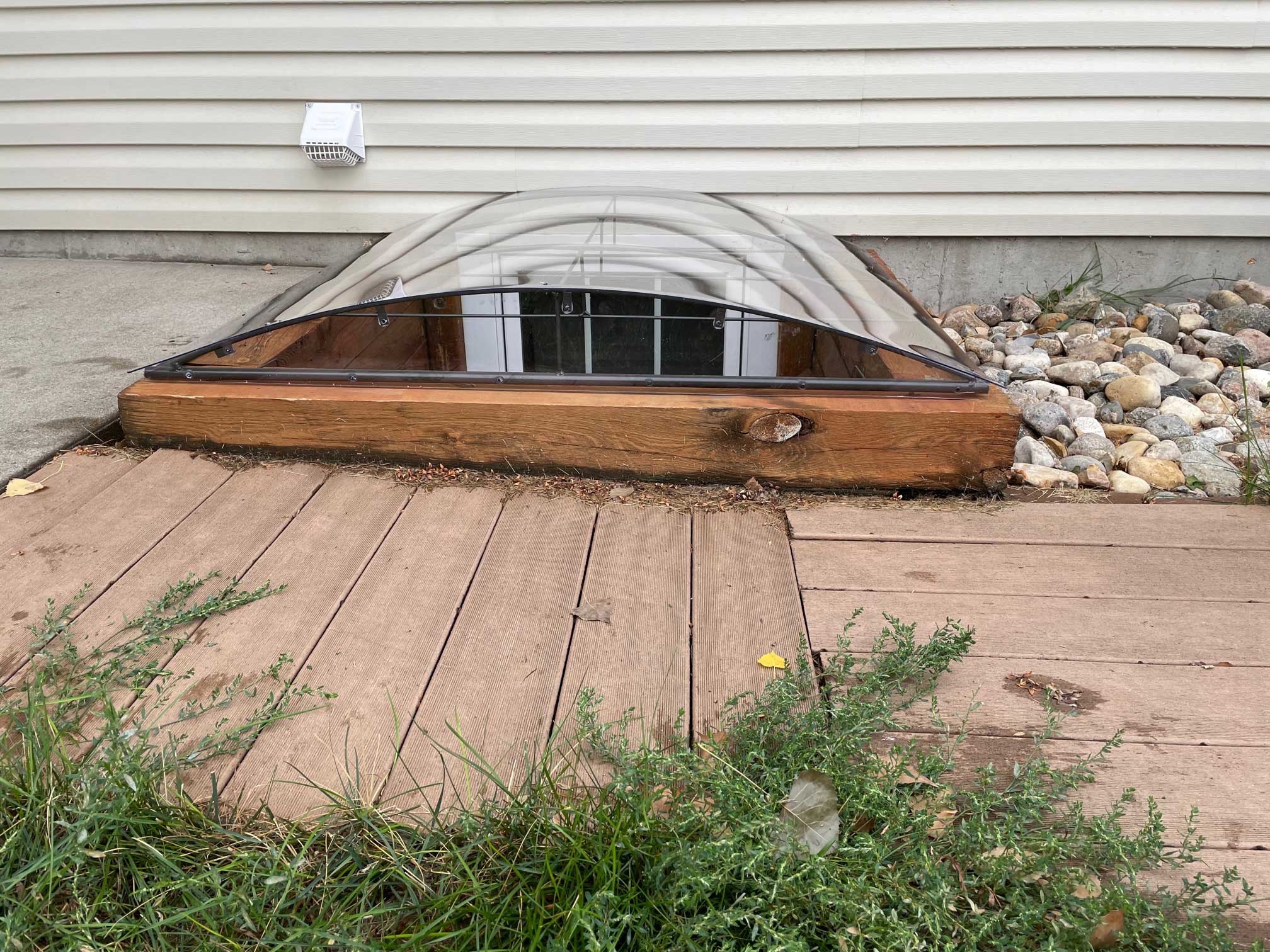 Basement window with curved clear well cover
