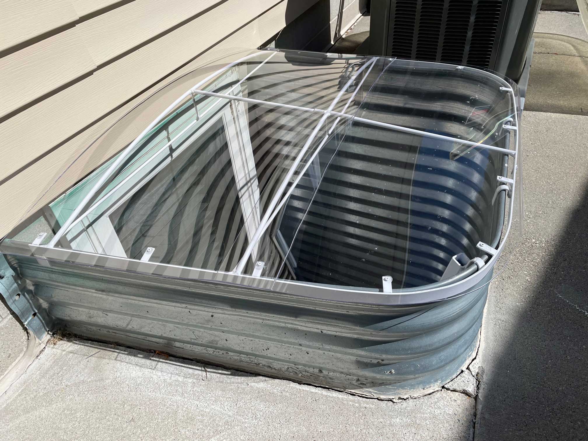 Basement window well with clear plastic cover