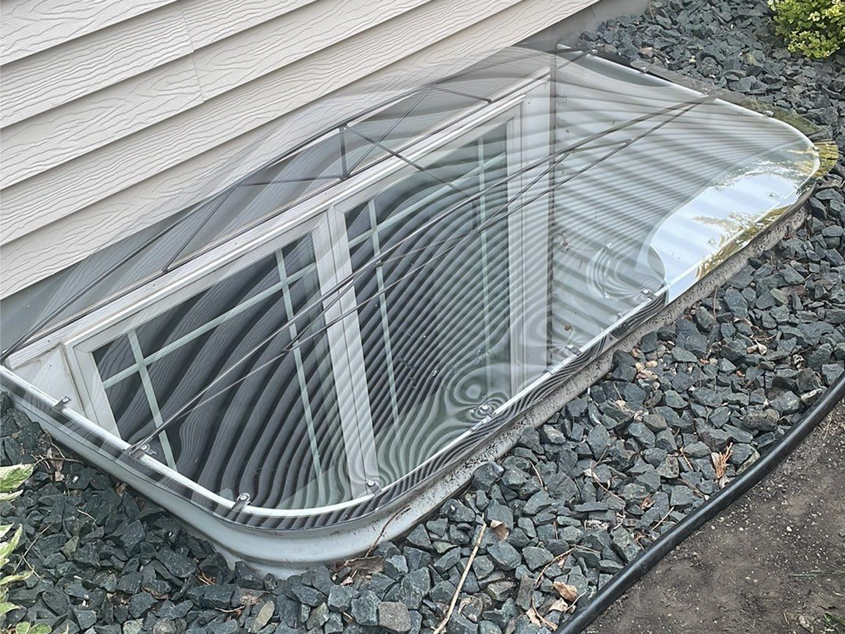 Transparent window well cover over basement window