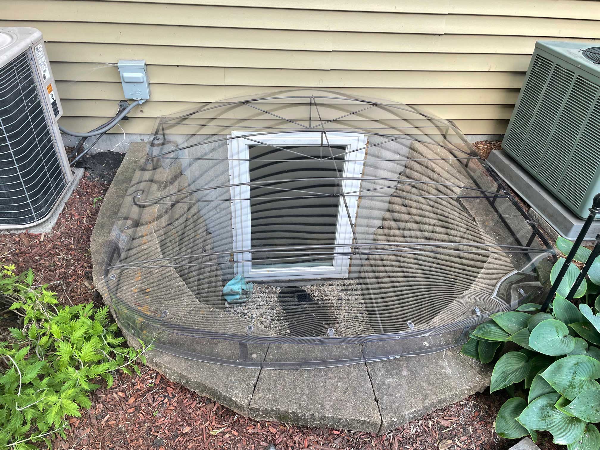 Basement window well with protective mesh dome