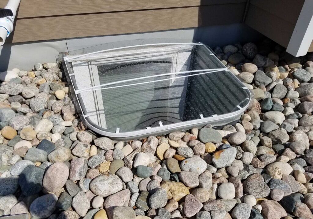 Basement window well with stone cover